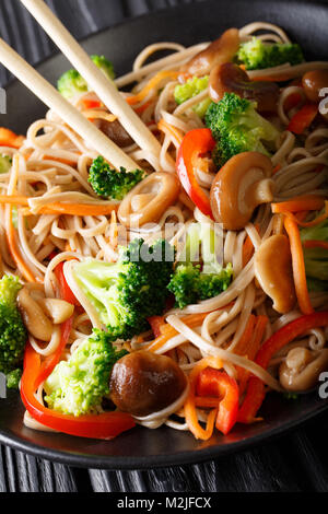 Nouilles soba sarrasin frit aux champignons et les légumes sur une plaque verticale. Banque D'Images