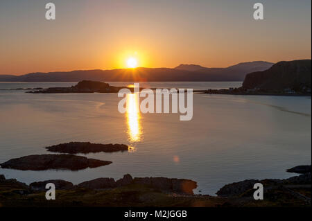 Superbe vue sur le village d'Easdale Ellenabeich Île Seil Island, Ecosse, comme le soleil se couche derrière l'île de Mull de l'autre côté de l'eau Banque D'Images