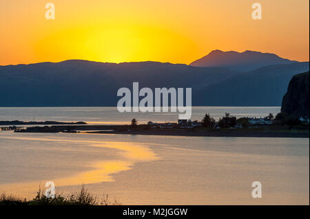 Superbe vue sur le village de l'Île Seil / Ellenabeich, Ecosse, comme le soleil se couche derrière l'île de Mull de l'autre côté de l'eau Banque D'Images