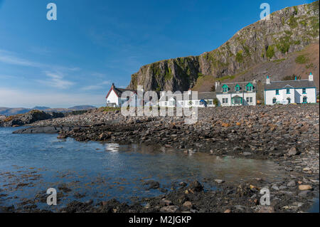 Superbe vue sur le village de l'Île Seil Ellenabeich, Ecosse, avec cottages blancs à la base de la falaise rocheuse Banque D'Images