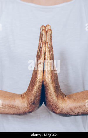 Close-up of golden femme les mains dans une pose de yoga, de l'ossature verticale Banque D'Images