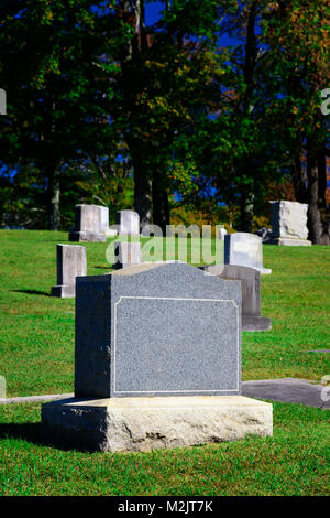 Shot verticale d'une pierre tombale blanche dans un cimetière. Banque D'Images