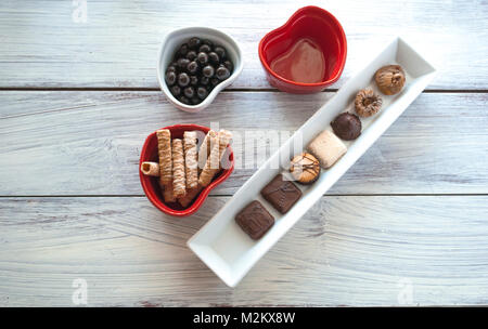 3 bols en forme de coeur avec des petits gâteaux et bonbons sur la table. Partager histoire concept. Love Story concept. Valentines. Notion de famille. Valentine day Banque D'Images