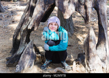 Young caucasian woman in winter clothing pose entre les arbres Séquoia géant Banque D'Images