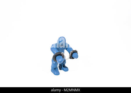 Petit bleu figure dans les menottes. Fait à partir de jouer de l'argile. Isolé sur fond blanc. Banque D'Images
