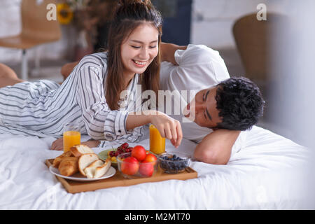 Les jeunes couples ont un petit déjeuner au lit Banque D'Images