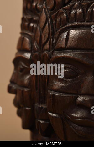 Libre d'un masque en bois sculpture du Cambodge, montrant deux visages à la perpendiculaire à l'autre avec l'avant face à la sculpture en focus. Banque D'Images