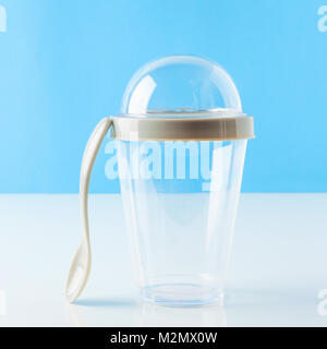 Jetables en plastique vide avec couvercle tasse lait frappé. Transparent. Conteneur pour le froid, boisson chaude. Frais de jus, café, thé. sur le tableau blanc et blue background Banque D'Images