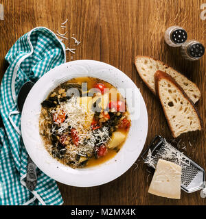 Chou frisé (ou cavolo nero) et d'orge de la soupe. Soupe de légumes d'hiver sur une table en bois et du pain frais Banque D'Images