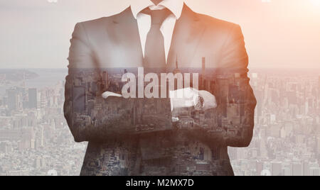 Double exposition de réussite business man with arms crossed et ville en arrière-plan. Vie homme Concept Banque D'Images
