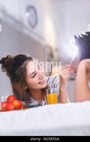 Les jeunes couples ont un petit déjeuner au lit Banque D'Images