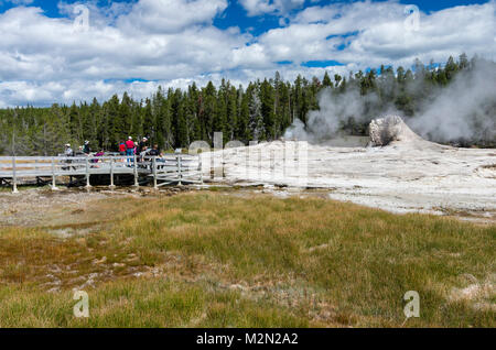 Les touristes observant le geyser de Mastiff à Upper Geyser Basin complexes. Le Parc National de Yellowstone, Wyoming, USA Banque D'Images