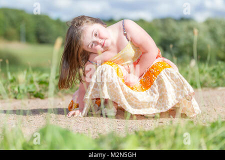 Jeune fille avec le syndrome de Down profitant de l'ensoleillement du matin avec grandparants. Banque D'Images