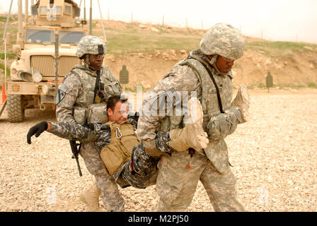 Buddy s'acquitter. SITE D'EXPLOITATION D'URGENCE MAREZ, Iraq - PFC. Luther Alston (à droite) et de la CPS. Oriola Owokoya (à gauche), les deux médecins affectés au siège et le Siège Batterie, 5e Bataillon, 82e Régiment d'artillerie, 4e Brigade d'aider et de conseiller, Division de cavalerie, démontrer une méthode rapide pour transporter un blessé lors d'une formation à l'Ghuzlani Eagle Training Centre, 9 mars 2011. Alston, originaire de Warrenton, N.C., et Owokoya, originaire de Lagos, Nigeria, enseigné policiers iraquiens de 3e Police fédérale des compétences dans le cadre d'une classe de formation de six jours pour développer la Banque D'Images