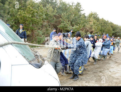 MISAWA, au Japon (19 mars 2011) - les membres du Service et les résidants de la ville de Misawa tirer un véhicule endommagé de la forêt près de Misawa port de pêche. Les membres du service, les employés civils et les membres de la famille de Misawa Air Base rejoint avec les résidents de la ville de Misawa pour nettoyer le port après un tremblement de terre de magnitude 9,0 qui a provoqué un tsunami dévastateur le long de la côte est du Japon. (U.S. Photo par marine Spécialiste de la communication de masse 1re classe Matthieu M. Bradley/libérés) 110319-N-2653B-047 par le commandant des Forces navales des États-Unis, Japon (CNFJ) Banque D'Images