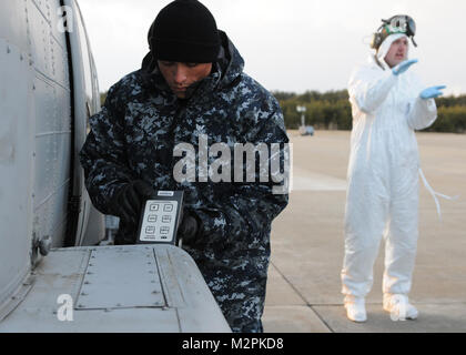 110323-N-MU720-051 MISAWA AIR BASE, le Japon (23 mars 2011) 1ère classe Mate du machiniste Jose Hurtado de Bridgeport, Connecticut, et affectés à l'entretien régional nucléaire Ministère, Kings Bay Ga., effectue une évaluation post sortie à l'extérieur d'un hélicoptère affecté à l'Escadron d'hélicoptères de lutte anti-sous-marine 14. Ces efforts sont menés à Misawa Air base pour assurer la sécurité des membres de l'équipage et leur environnement comme missions de secours humanitaire continuent de voler à partir de la Naval Air Facility Misawa à l'appui de l'opération Tomodachi. (U.S. Photo par marine Spécialiste de la communication de masse 2e classe D Banque D'Images