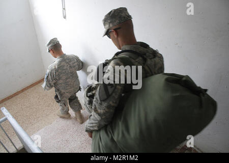 D'emballer, déménager. SITE D'EXPLOITATION D'URGENCE MAREZ, Iraq - Un soldat affecté aux pays fournisseurs B, 1er Escadron, 9e régiment de cavalerie, 4e Brigade d'aider et de conseiller, Division de cavalerie, porte ses sacs dans un camion à la station commune de sécurité 4 dans la province de Ninewa Whisky, l'Iraq, le 29 juillet 2011. Environ 200 civils et soldats américains affectés aux pays fournisseurs B a vécu à la base d'octobre 2010 jusqu'à août 2011, tout en soutenant les opérations de consultation et de formation avec les forces irakiennes au cours de l'opération nouvelle aube. (U.S. Photo de l'armée par le capitaine Philip Crabtree, 4e AAB PAO, 1st Cav. Div., USD - N) L'emballage Banque D'Images