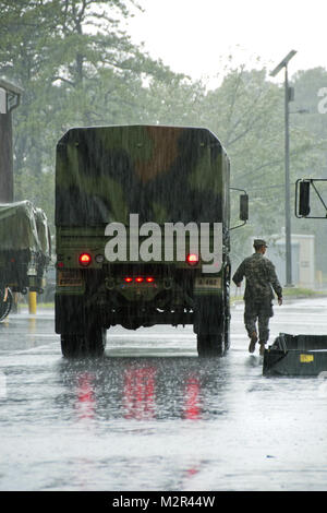 New Jersey Army National Guard (NJARNG) membre Le s.. Pierre Merle R. guide terrain effectue une pluie battante en franchise pour un véhicule léger tactique moyen (LMTV) car il est placé à la 177e Escadre de chasse dans la région de Egg Harbor Township, N.J., le 27 août. Unités d'NJARNG de Cape May, Teaneck et Vineland monté leurs appareils et véhicules à l'ouverture récente du 227e Escadron d'opérations d'appui aérien (OSS) qui se préparent à l'arrivée de l'ouragan Irène. (U.S. Air Force Photo par le Sgt. Andrew J. Moseley, 177FW/PA) NJ Air National Guard l'ouragan Irène Préparation par la Garde nationale Banque D'Images