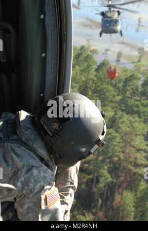 CADDO PARISH Louisiane - garde nationale la CPS. Steven Ferguson, chef d'équipe de Baton Rouge, en Louisiane, guide le UH-60 Black Hawk à un point chaud à l'extérieur de Shreveport, en Louisiane, dans la région de Caddo Parish, le 6 septembre 2011. Les pilotes LANG a travaillé dans un modèle d'hippodromes de vider l'eau sur les points chauds à proximité de l'autoroute 1 et 528 en utilisant helibuckets -grand seaux pour transporter de l'eau suspendue par câble à aider le Ministère de l'Agriculture et de la forêt avec la suppression du feu sauvage. (U.S. Photo de l'armée par le Sgt. Rebecca, la Garde nationale de la Louisiane Malone/Bureau des affaires publiques/libérés) 110906-A-ZD968- par Louisia Banque D'Images