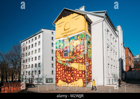 Minsk, Belarus. Des graffitis ou des peintures murales d'Os Gemeos Street Art artiste brésilien sur le mur de l'Ambassade du Brésil. Big Yellow Giant assis avec ses longues jambes FOL Banque D'Images