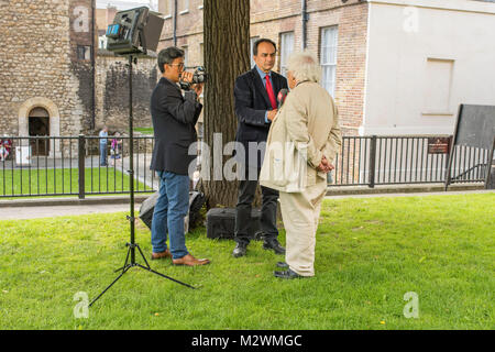 Les journalistes interviewant un homme sur l'herbe en face du Palais de Westminster, Londres, Royaume-Uni. Banque D'Images