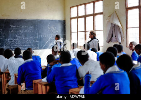 Kibuye/Rwanda - 08/26/2016 : Professeur et élèves de leçon de mathématiques dans une classe dans une école en Afrique. Un tableau noir et peut être vu dans le b Banque D'Images