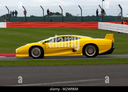 Vue latérale d'une Jaguar XJ220 jaune en prenant part à l'anniversaire des défilés autour du circuit de course historiques, au cours de la 2017 Silverstone Classic Banque D'Images