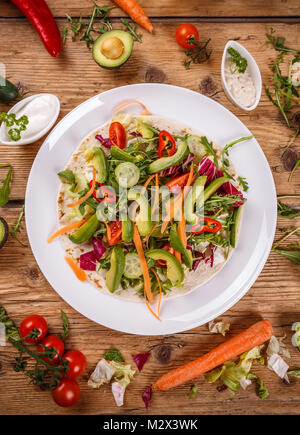 Salade végétalienne saine tortillas sur fond de bois Banque D'Images