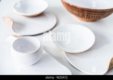 Ensemble de belles céramiques faites à la main, divers plats et assiettes à la main sur fond blanc Banque D'Images