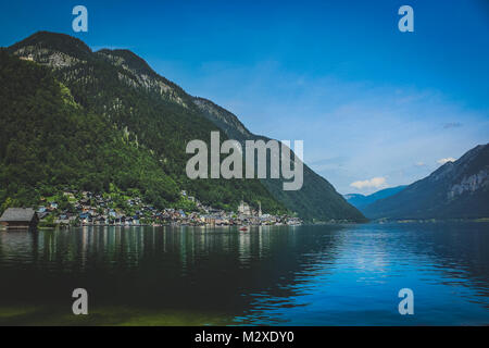 Vue panoramique sur le pittoresque village au bord du lac de Hallstatt à la base d'une haute montagne alpine sur une journée ensoleillée avec des reflets dans l'eau, Hamburg Banque D'Images