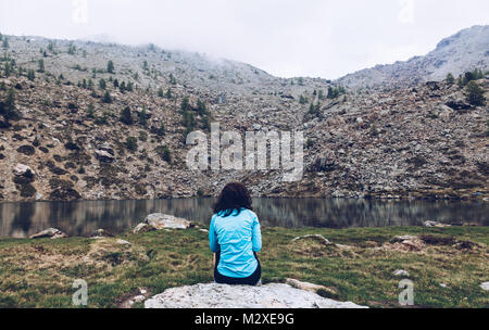 Fille de randonnée dans les montagnes se détendre devant à un lac silencieux en italie - Aoste Banque D'Images