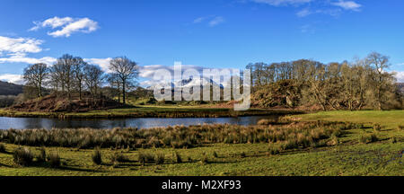 Panorama de la rivière Brathay comme il court entre Great Langdale et Skelwith pont avec la neige a couvert la distance en Wetherlam. Banque D'Images