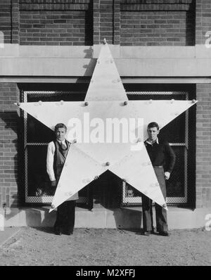 Deux jeunes hommes qui occupent une grande star, ca. 1940. Banque D'Images