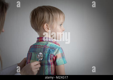 Petit garçon au médecin, femme à l'aide de stéthoscope Banque D'Images