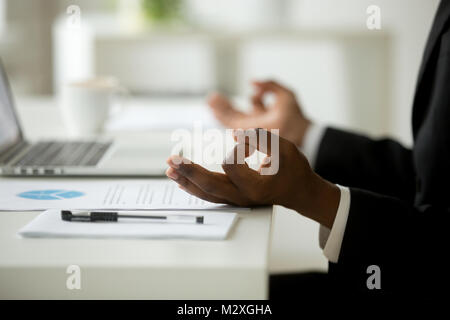 African American businessman calme méditant dans office, chef de la pacifique en fonction de la pratique du yoga au travail, se concentrer sur l'homme noir dans les mains mudra, succ Banque D'Images