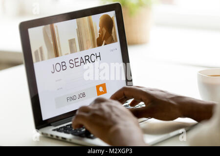 Homme africain parcourt les possibilités d'emploi en ligne à l'aide de l'ordinateur à la recherche d'emploi, demandeur d'emploi de l'application black à la recherche de nouveaux postes vacants sur le site web page at laptop Banque D'Images