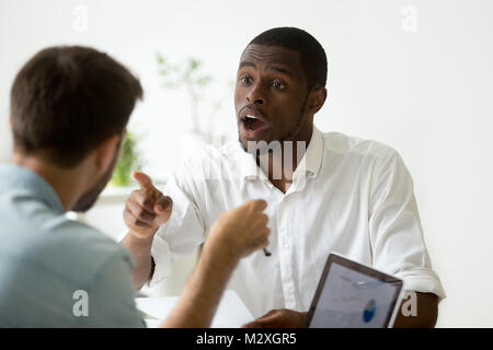 African American businessman en désaccord arguant de débattre pendant les négociations, négociateur noir avec contestante partenaire caucasiens, insistant sur Banque D'Images