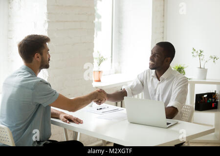 African American and Caucasian businessmen shaking hands over de Banque D'Images