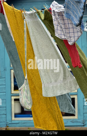 Torchons et serviettes de flâner sur un lave-ligne tenue avec des pointes et des rafales de vent dans la blanchisserie. lave sur une ligne d'articles de blanchisserie colorés. Banque D'Images