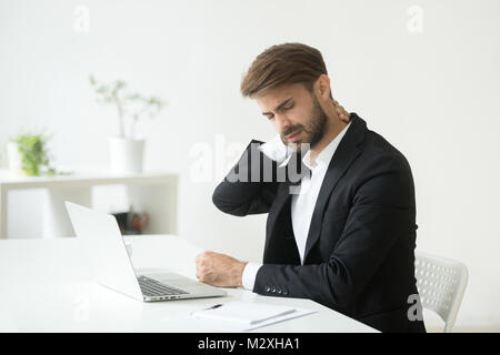 Young Woman in suit le sentiment d'une douleur au cou après le travail sédentaire Banque D'Images