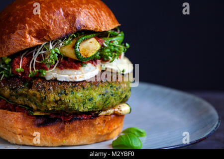 Burger végétarien fait de petits pois, haricots beurre et les épinards avec pesto de tomates séchées et de courgettes grillées Banque D'Images