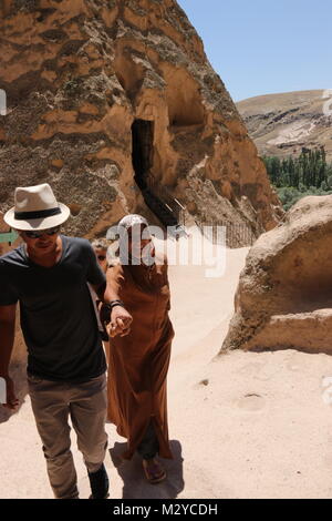 Les touristes visitant quelques-unes des célèbres cheminées de fées en Cappadoce qui ont été fouillées par les gens à être utilisés comme maisons et églises en Turquie Banque D'Images