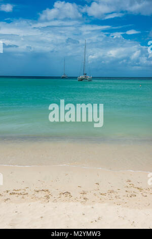 Bateau à voile s'ancrant dans les eaux turquoise de la plage rouge de Mourne, Grenade, Caraïbes Banque D'Images