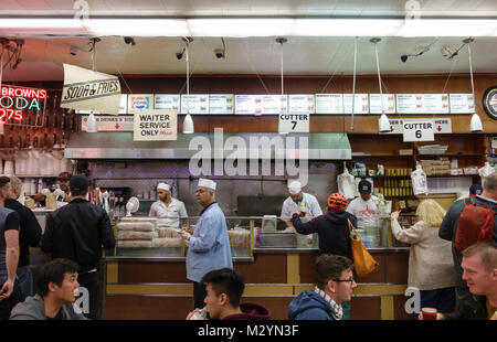 Les clients, les serveurs et le personnel de cuisine au guichet au Katz's Delicatessen, un célèbre New York City Restaurant deli juif. Banque D'Images