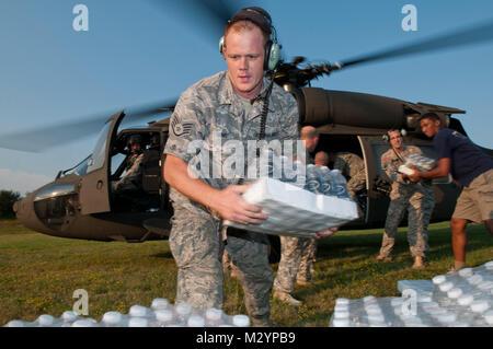 Le s.. Steve J. les mei, 130e Airlift Wing, West Virginia Air National Guard permet de décharger l'eau en bouteille d'un UH-60 Black Hawk, à Lewisburg, W.Va., à la Compagnie Charlie 1er/201e de la Virginie de l'ouest d'artillerie de la Garde nationale de l'armée. Les résidents de la région sont le troisième jour de la vie sans pouvoir en 90 degré de chaleur dû à une violente tempête qui a balayé la région vendredi soir. Violente tempête Réponse de la Garde nationale Banque D'Images