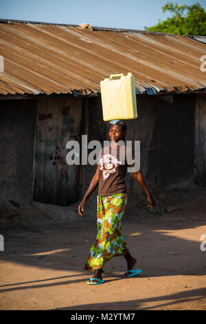 Femme transportant un bidon d'eau sur sa tête, apportant l'eau dans le lac Albert, à la maison de l'Ouganda, l'Afrique Banque D'Images