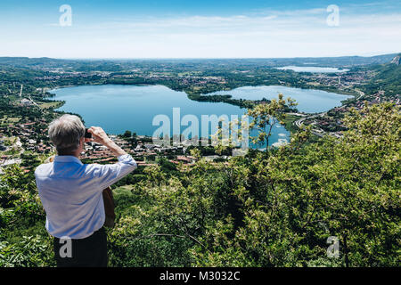 Un pensisioner prendre photo de la vue panoramique depuis le Monte Barro.Lombardie. L'Italie. Banque D'Images