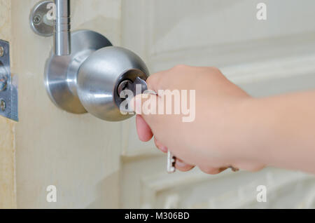 Par contre le bouton de déverrouillage de la touche de déverrouillage de porte à la poignée de porte en bois, l'acier inoxydable blanc bouton de porte ou de la poignée, le bouton main main porte appuyez sur le bouton de verrouillage de porte Banque D'Images