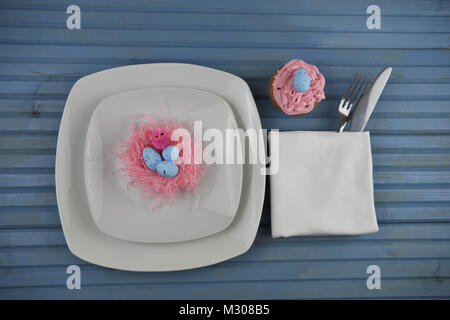 Table de pâques place mise en blanc avec décorations oeufs de Pâques et cupcake Banque D'Images