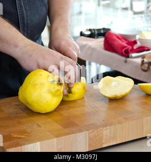 Couper les mains des hommes sur un coing jaune grande planche à découper en bois Banque D'Images